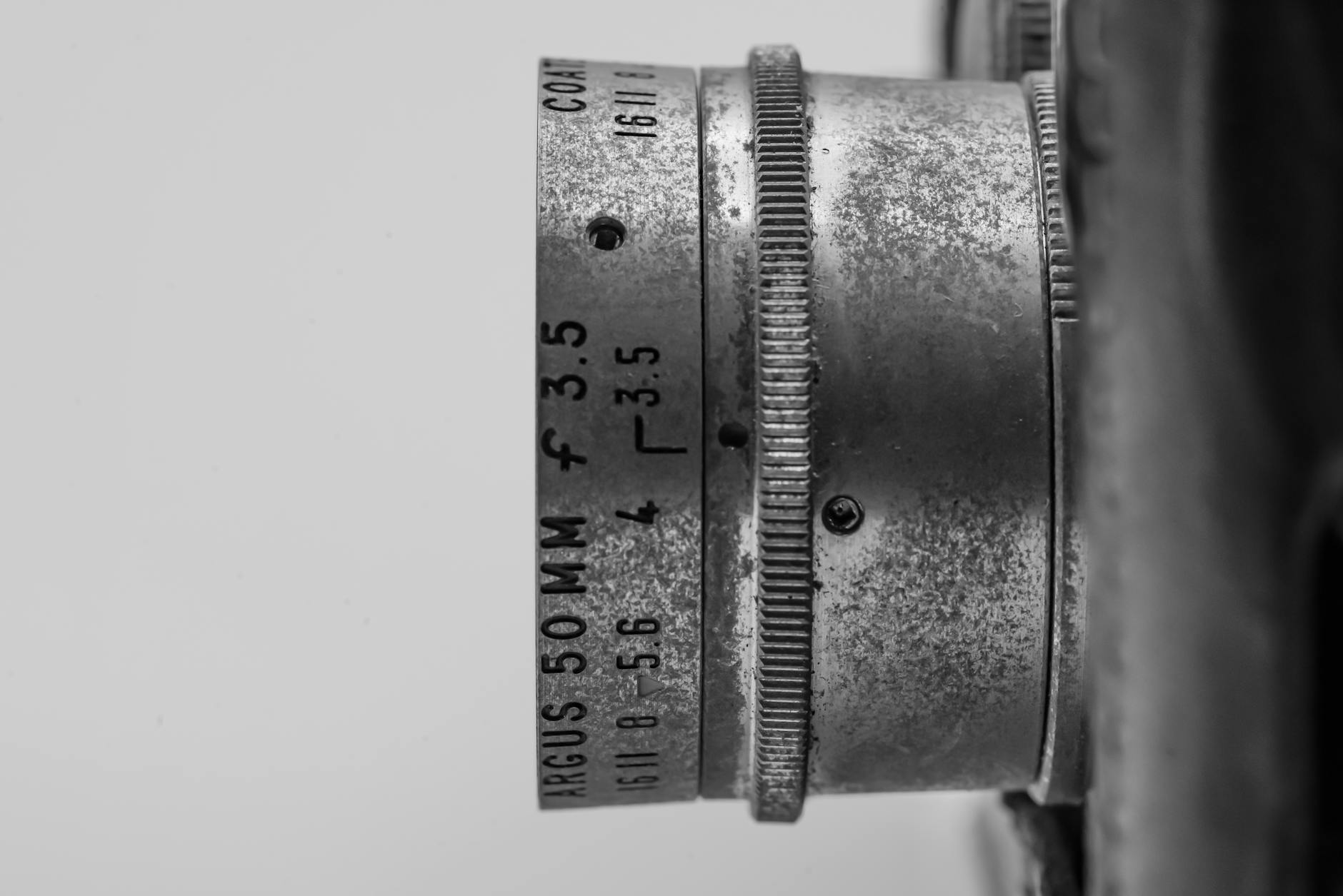 Detailed grayscale image of an Argus 50mm f/3.5 vintage camera lens showcasing classic design elements.