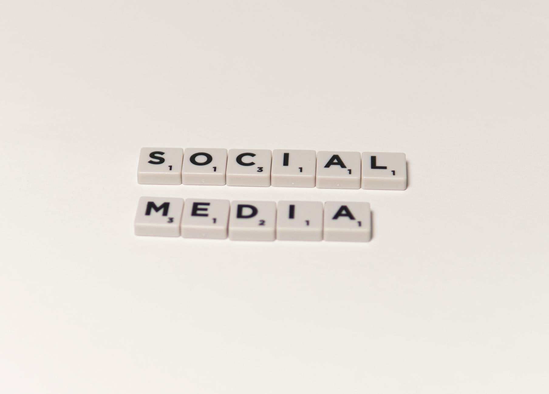 Scrabble tiles spelling 'social media' on a white background, representing digital communication concepts.