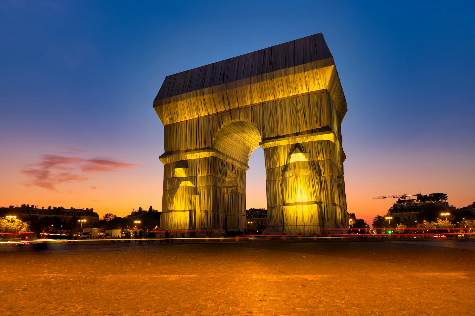 A stunning view of the Arc de Triomphe wrapped in fabric at sunset, showcasing art in Paris.