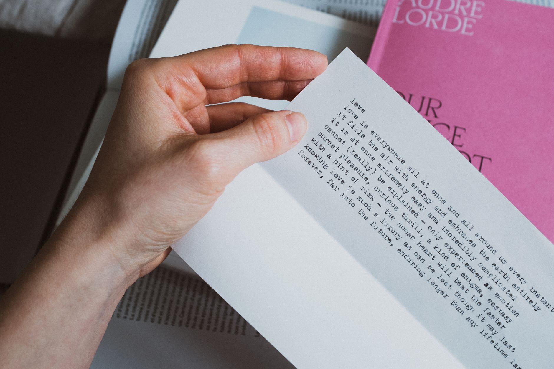 From above of crop person holding paper letter with inspirational quote in bedroom