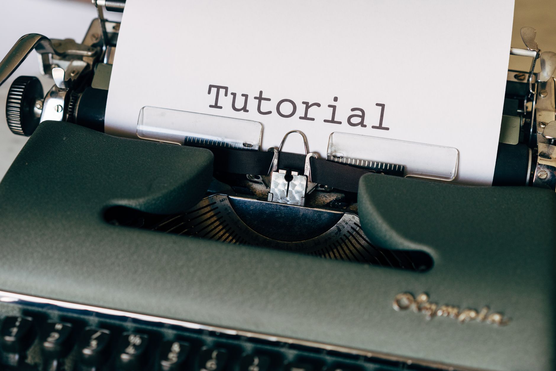 Close-up of a vintage typewriter with a sheet reading 'Tutorial'. Ideal for writing themes.