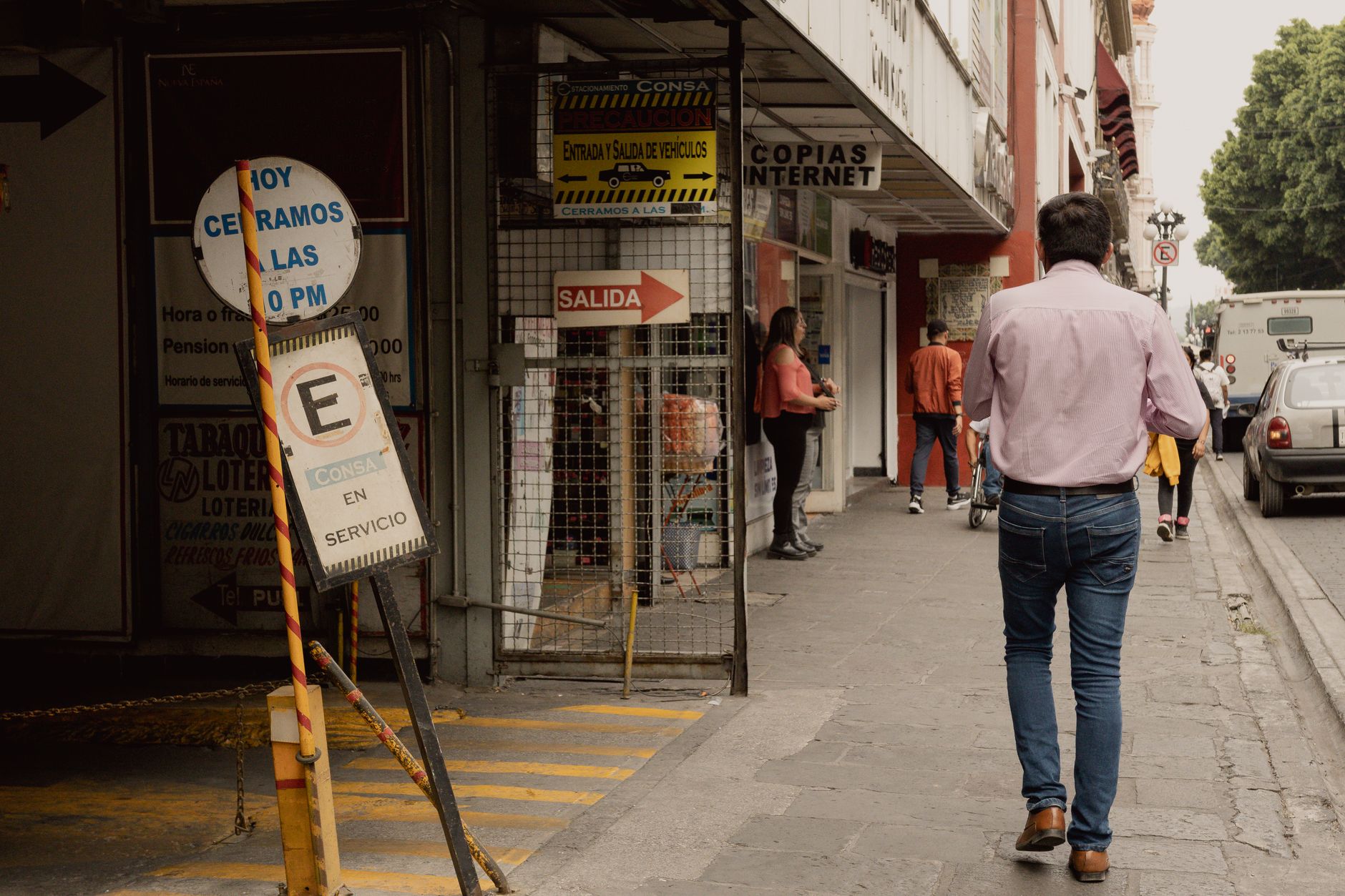 Vibrant city life on a street in Heroica Puebla de Zaragoza, Mexico featuring pedestrians and shops.
