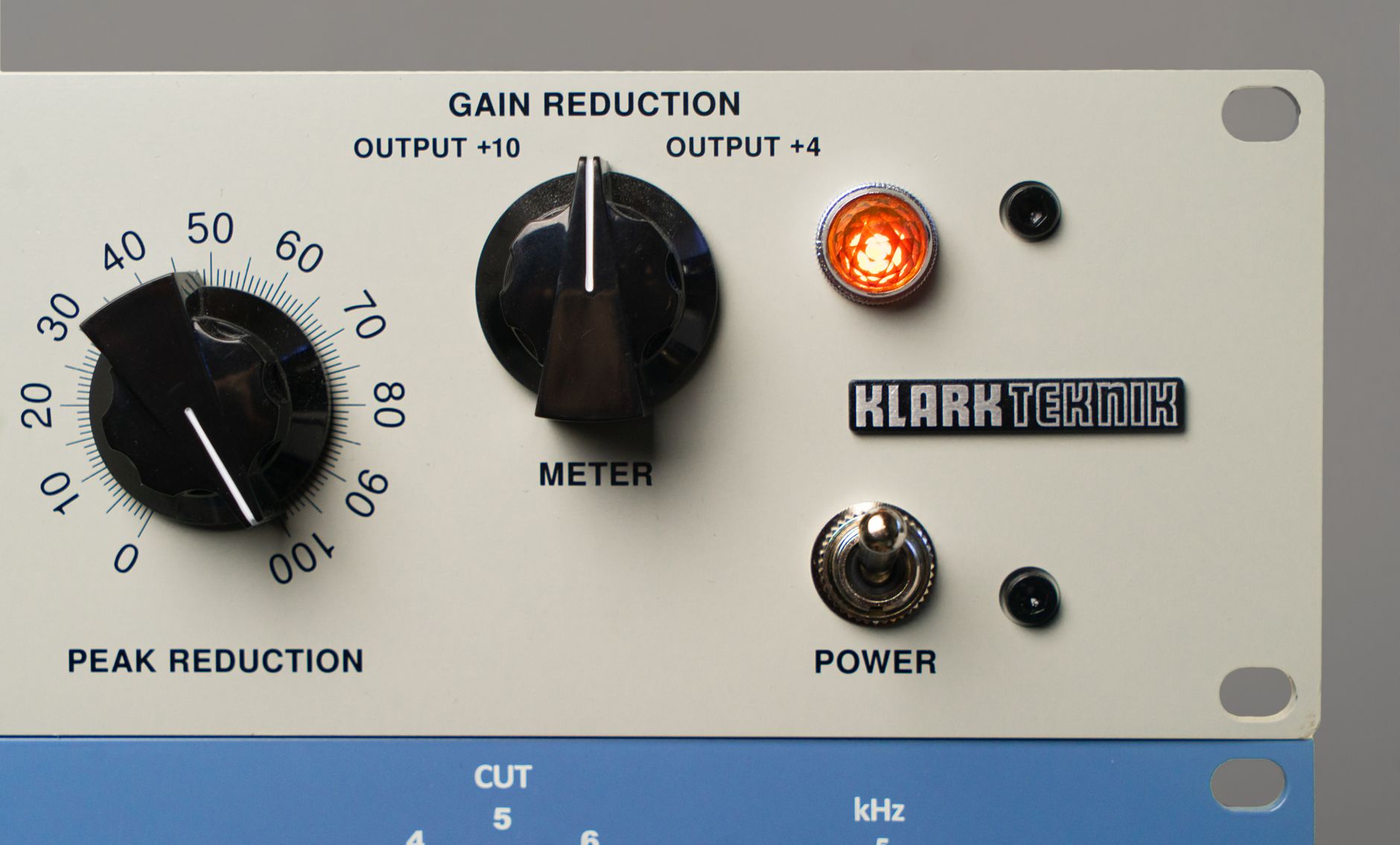 Detailed view of audio equipment featuring control knobs and meters for music production.