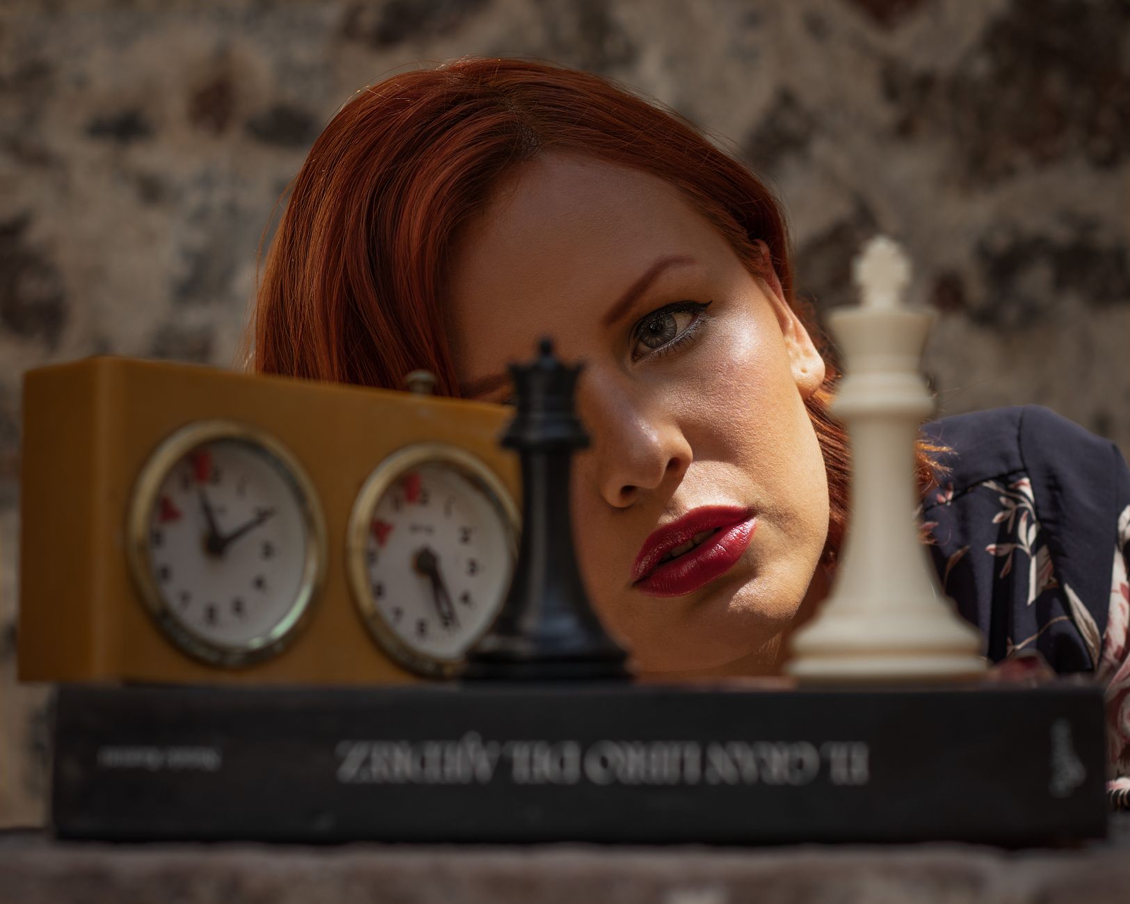 A woman in Ciudad de México poses with chess pieces and clock, exploring strategic themes.