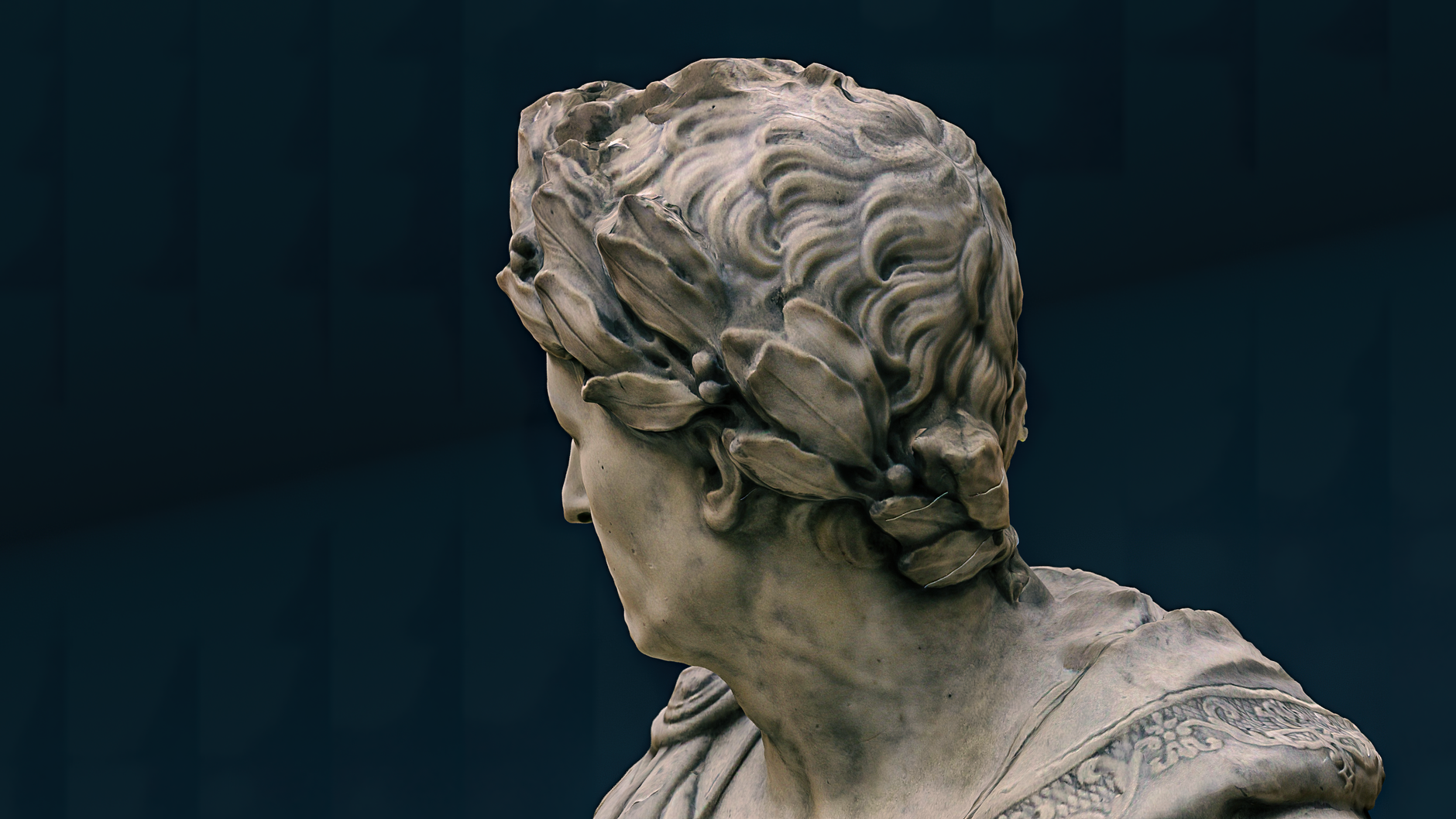 Close-up view of an ancient Roman marble statue showcasing intricate details of hair and laurel.