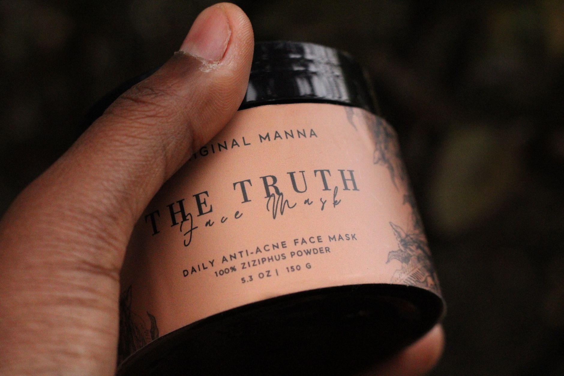 Close-up of hand holding 'The Truth' daily anti-acne face mask featuring Ziziphus powder.