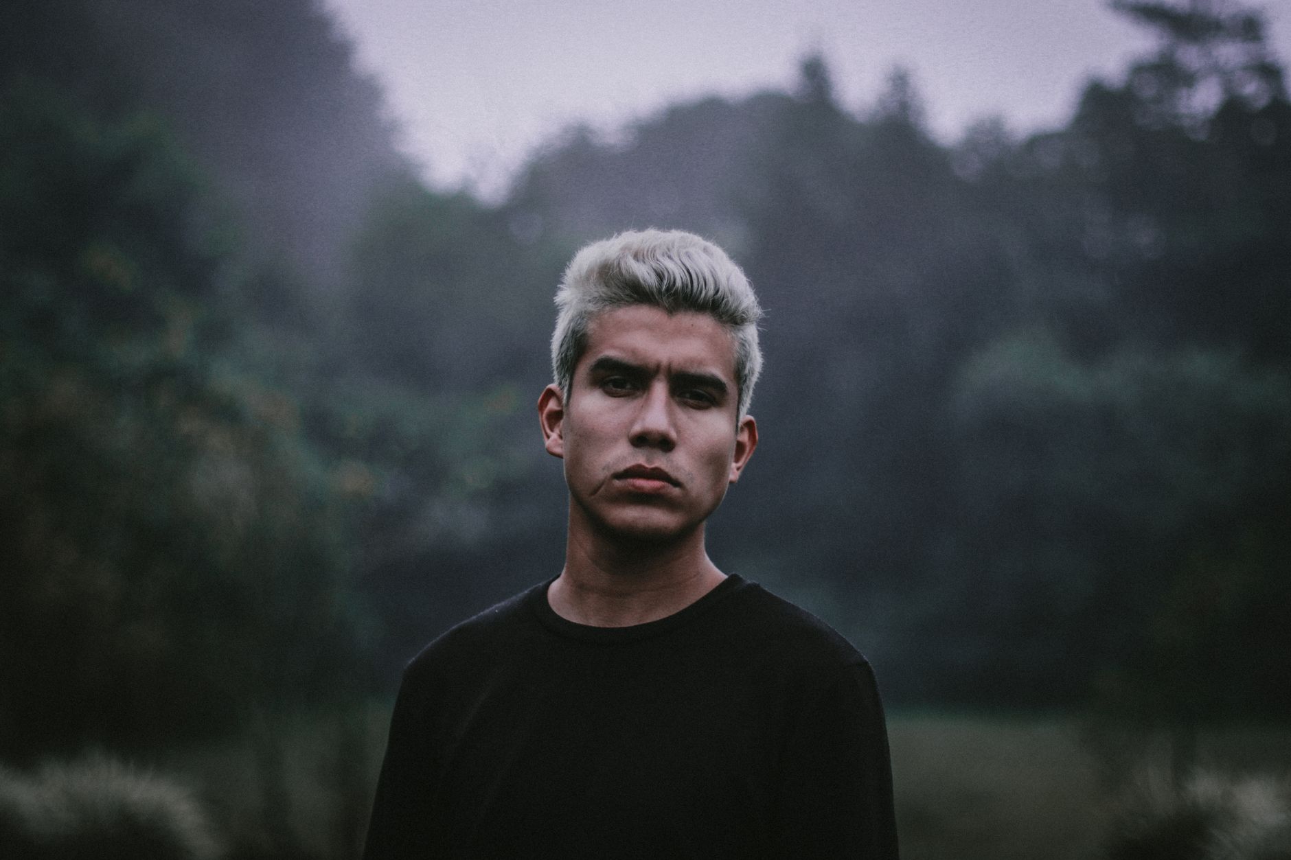 A striking portrait of a man with white hair in a misty forest in Chiriquí, Panamá.