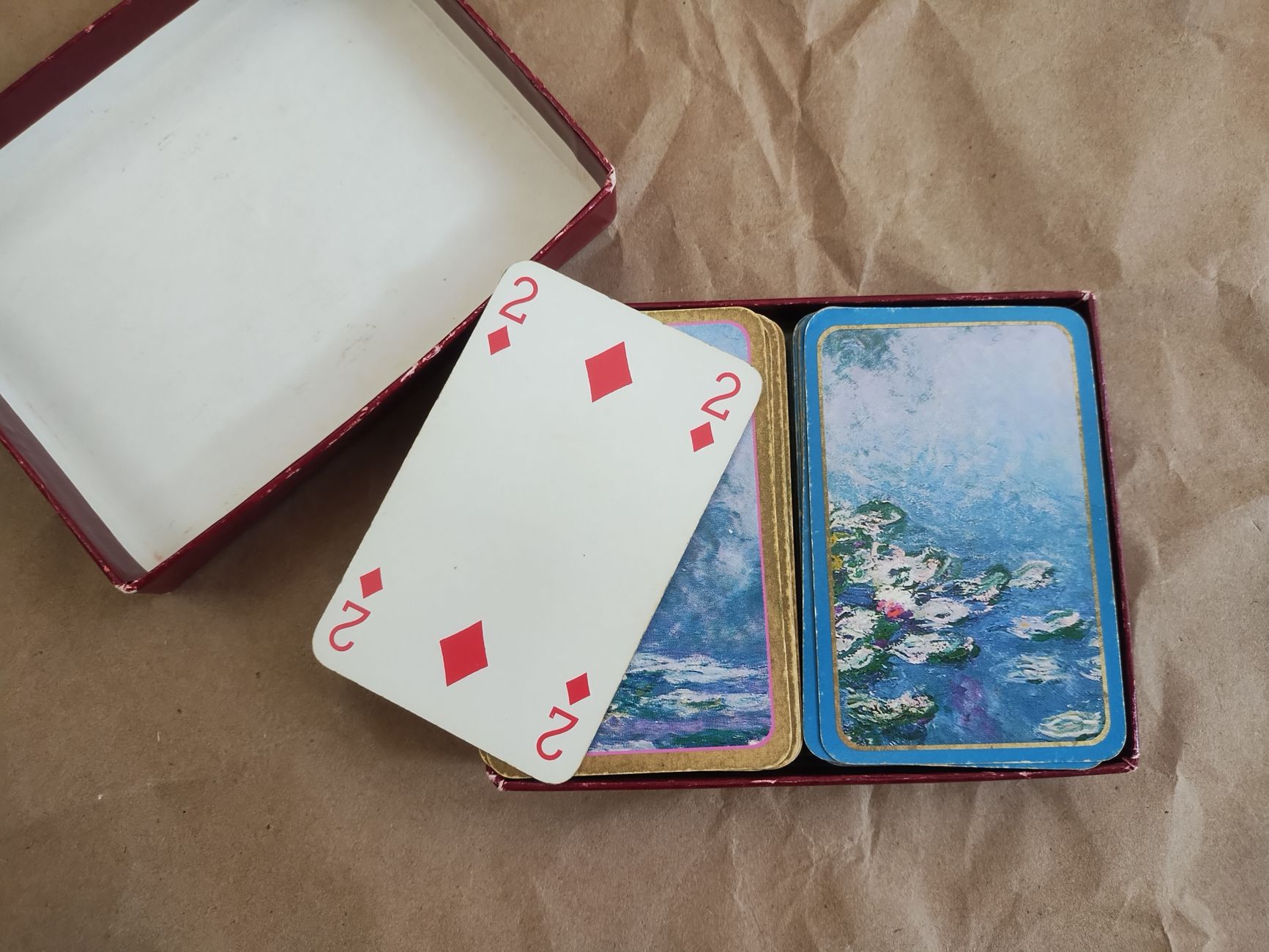 Close-up of vintage playing cards featuring art design on a rustic paper backdrop.